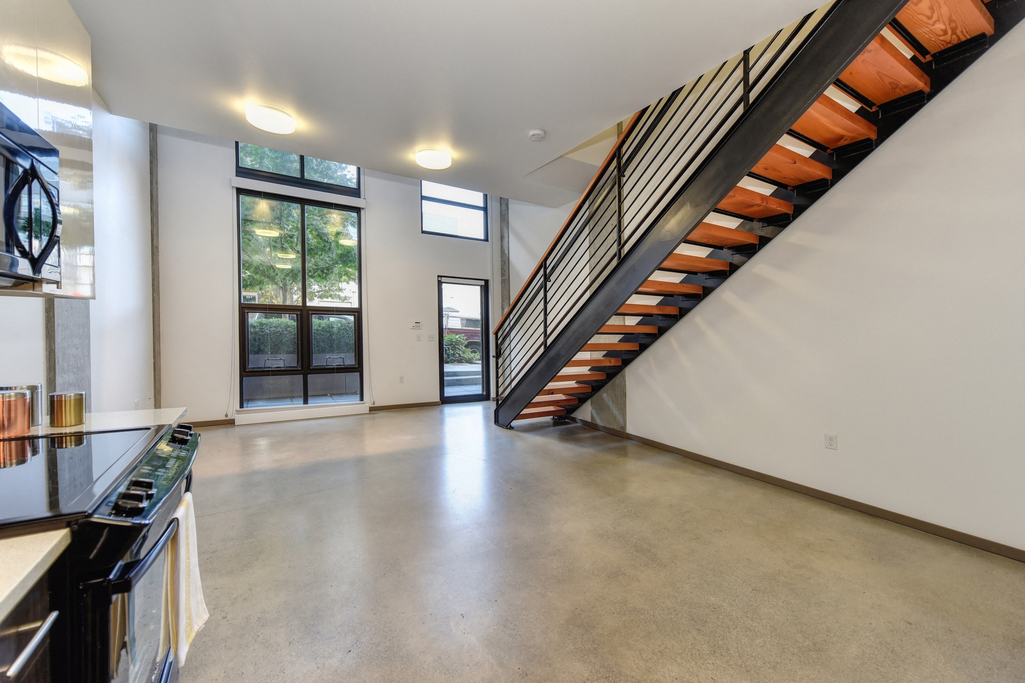 Staircase in Townhome with Side View of Oven, Windows and Solid Floor